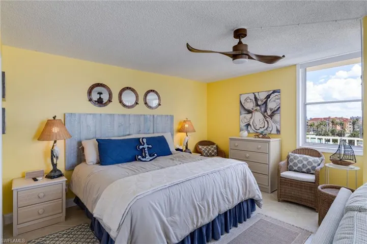 Tiled bedroom featuring ceiling fan and a textured ceiling