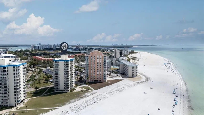 View of urban area featuring waterfront with a beach and apartment complex / building
