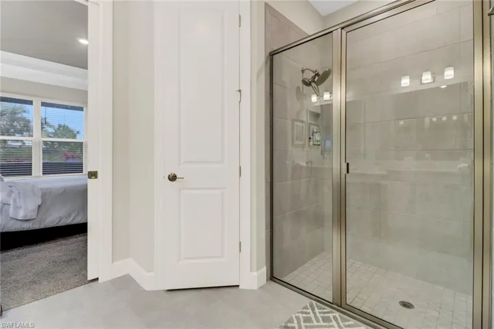 Bathroom featuring ensuite bath, a shower stall, and light tile patterned floors