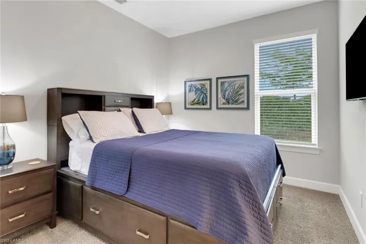 Bedroom with light carpet and baseboards