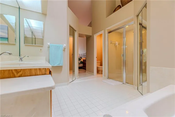Bathroom featuring tile patterned floors, vanity, toilet, and walk in shower