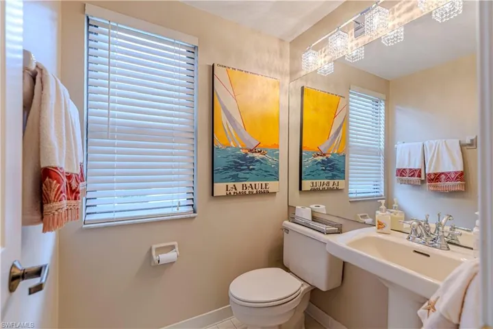 Half bathroom featuring toilet, plenty of natural light, and sink