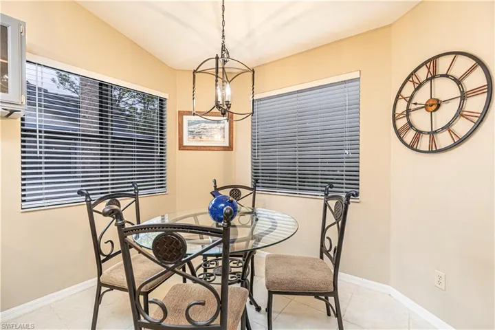 Dining area featuring lofted ceiling, light tile patterned floors, and an inviting chandelier