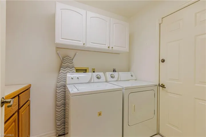 Laundry room with washer and clothes dryer and cabinets