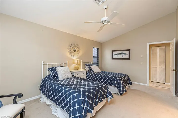Second bedroom with ceiling fan, lofted ceiling, and carpet floors