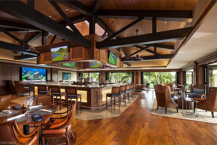 Bar with beamed ceiling, hardwood / wood-style flooring, high vaulted ceiling, and wooden ceiling