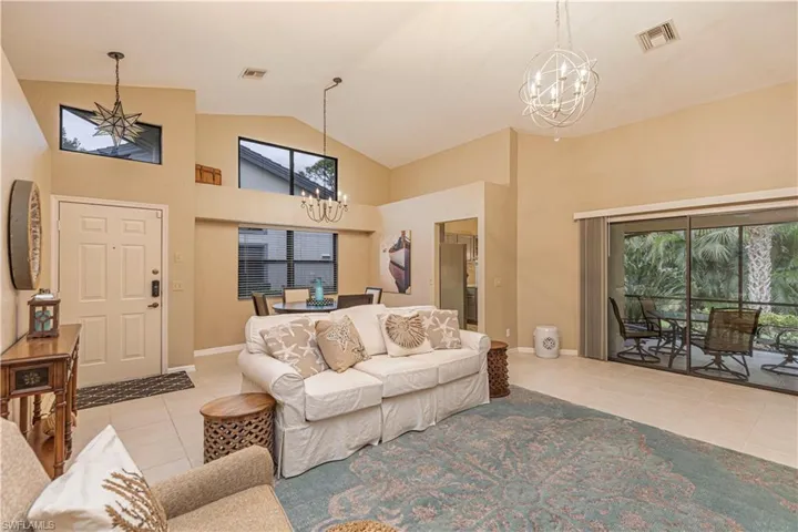 Tiled living room with high vaulted ceiling and an inviting chandelier