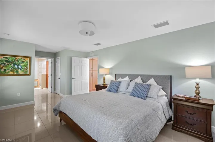 Bedroom featuring light tile patterned floors and connected bathroom
