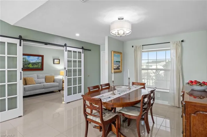Dining space featuring a barn door, light tile patterned floors, and recessed lighting
