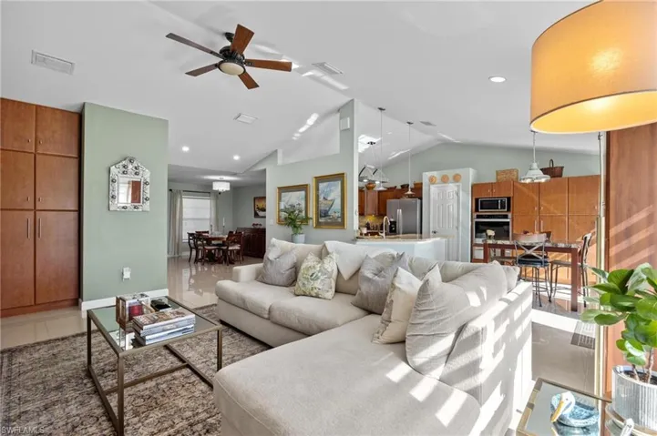 Living area with ceiling fan, lofted ceiling, and recessed lighting