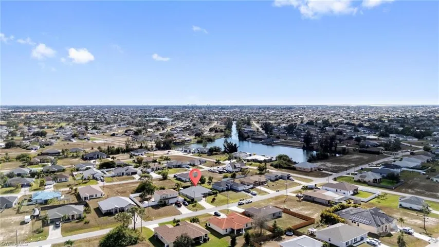 Aerial view of property's location with a nearby body of water and nearby suburban area