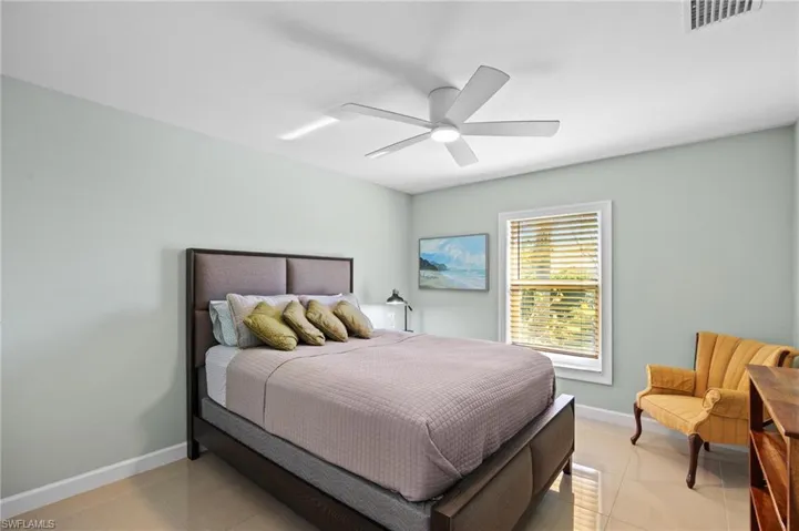 Bedroom featuring light tile patterned floors and ceiling fan