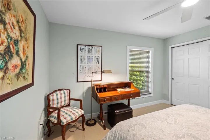 Bedroom featuring a closet, light tile patterned floors, and ceiling fan