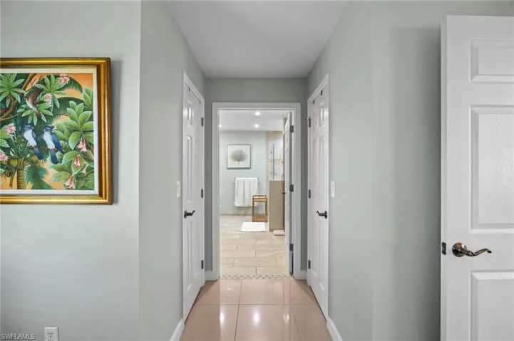 Hallway with light tile patterned flooring and baseboards
