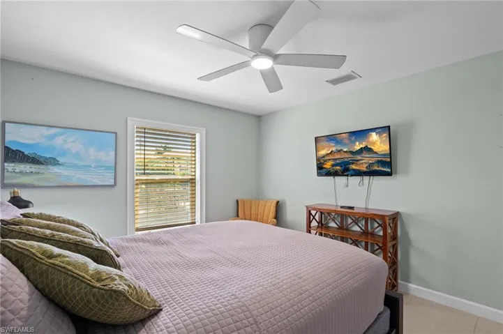 Bedroom with light tile patterned flooring and a ceiling fan