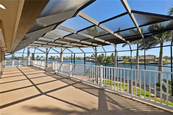 View of patio / terrace featuring a lanai and a water view