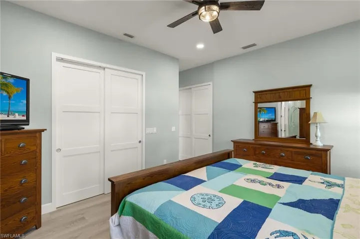 Bedroom featuring ceiling fan, light wood-style floors, visible vents, and a closet