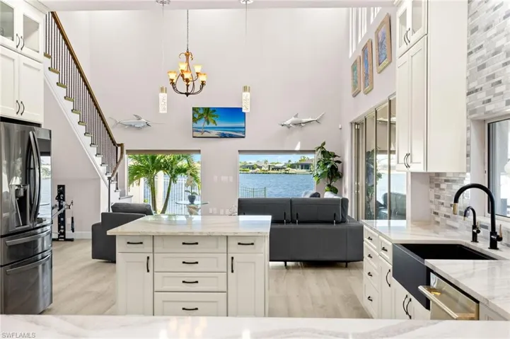 Kitchen with dishwasher, open floor plan, fridge with ice dispenser, and light wood-style floors