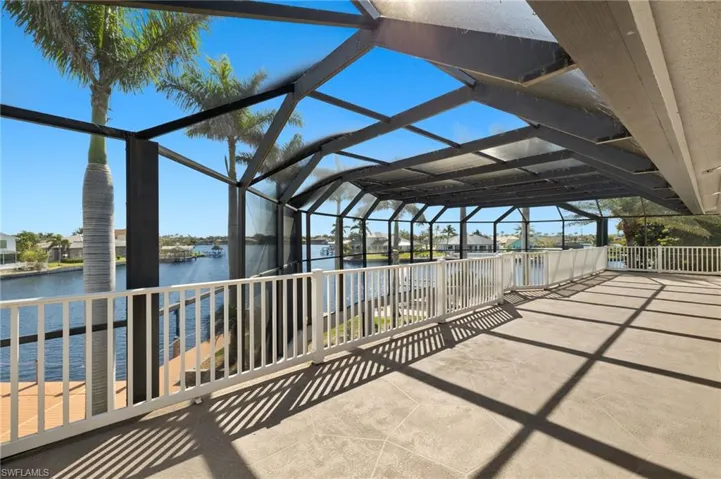 View of patio with glass enclosure and a water view