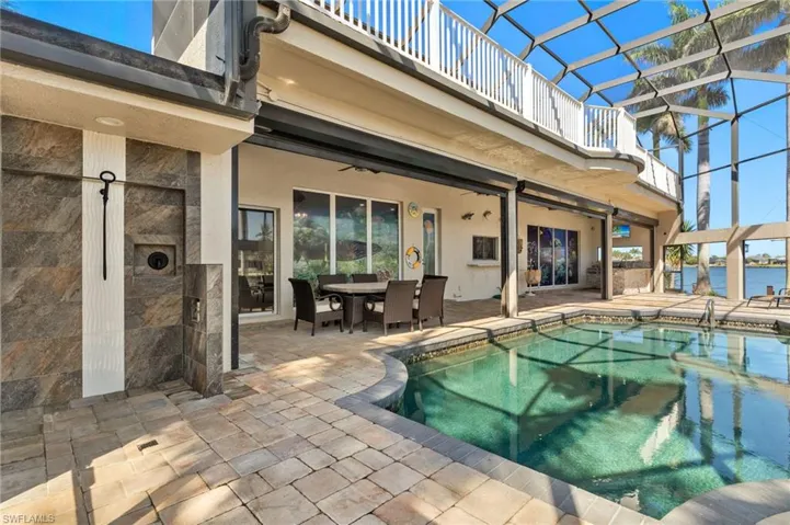 Outdoor pool featuring a lanai, a patio, ceiling fan, and outdoor dining area