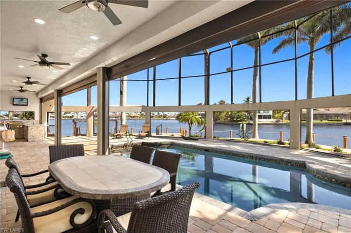View of swimming pool with a ceiling fan, a patio, exterior kitchen, and a swimming pool