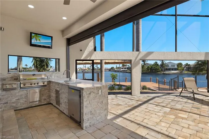 View of patio with a grill, ceiling fan, exterior kitchen, and a sink