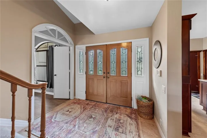 Tiled foyer with lofted ceiling