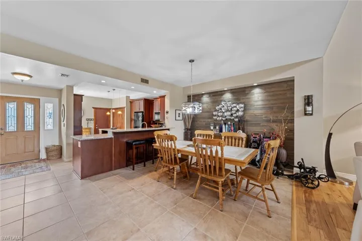 Dining area featuring light tile patterned floors and wood walls