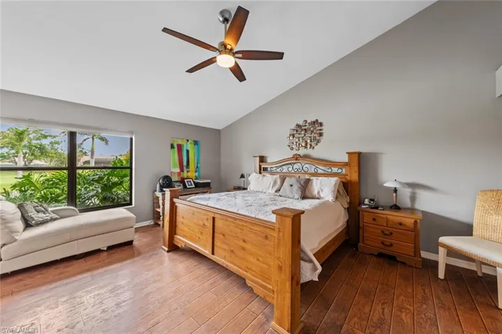 Bedroom with vaulted ceiling, wood-type flooring, and ceiling fan