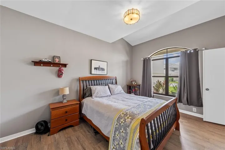 downstairs guest bedroom featuring hardwood / wood-style flooring
