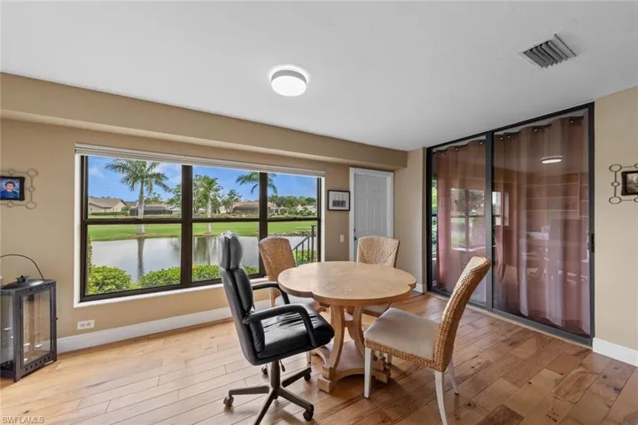 informal dining space with a healthy amount of sunlight, hardwood / wood-style floors, and a water view
