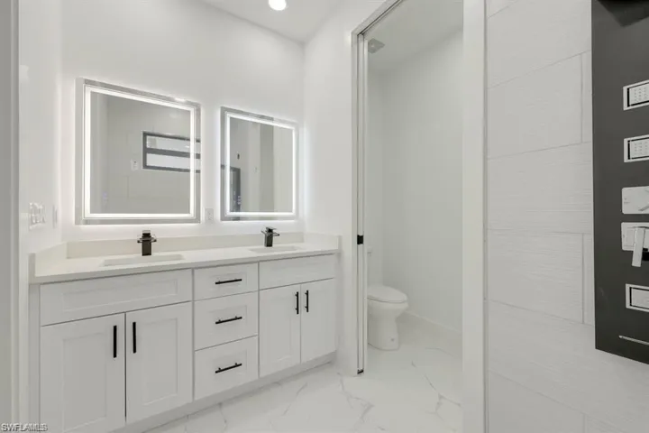 Bathroom featuring marble finish flooring and double vanity