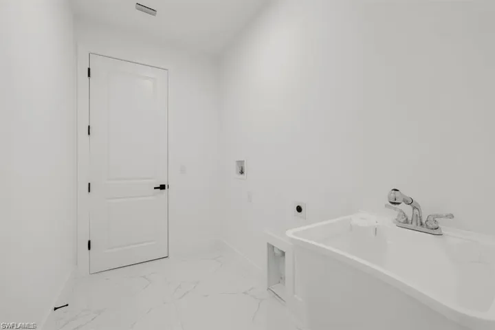 Laundry area featuring electric dryer hookup, washer hookup, and light marble finish floors