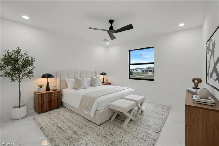 Bedroom with a ceiling fan, recessed lighting, and light marble finish floors