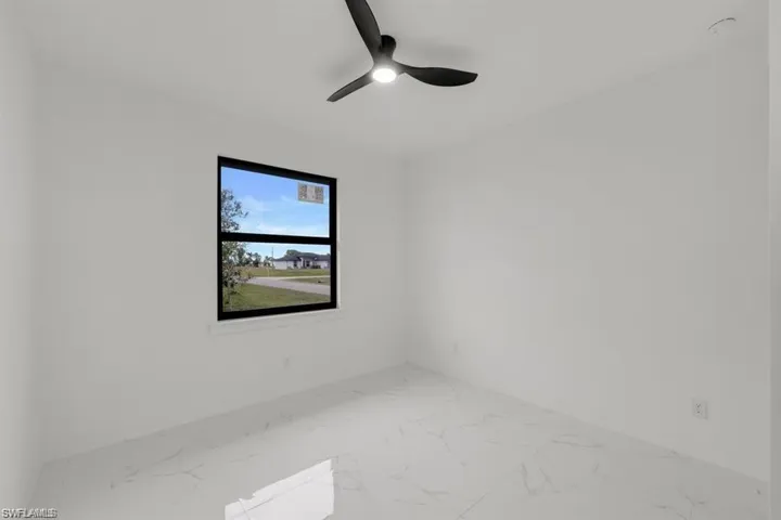 Empty room with marble finish floors and ceiling fan