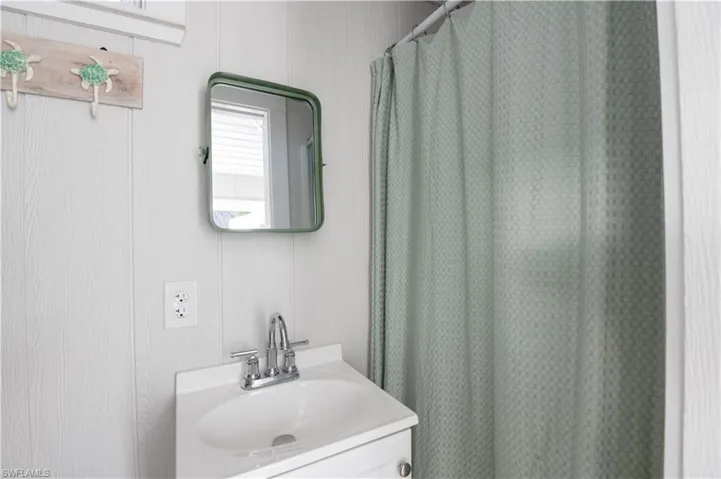 Full bath featuring curtained shower and vanity