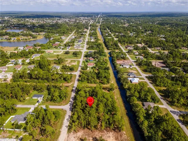Aerial view of property and surrounding area with a large body of water and nearby suburban area