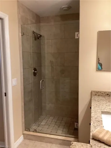 Bathroom with vanity, an enclosed shower, and tile patterned flooring