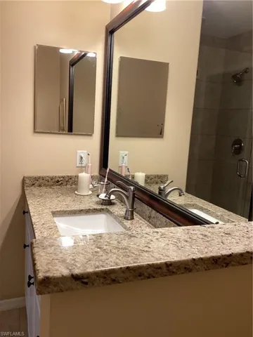 Bathroom with a shower with door and vanity
