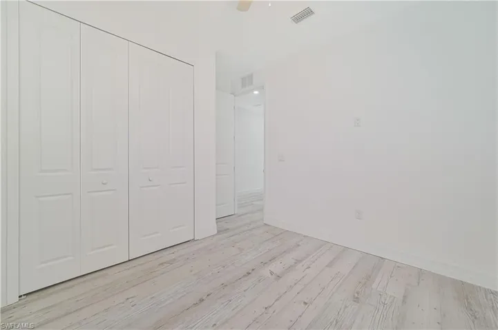 Unfurnished bedroom with ceiling fan, light hardwood / wood-style flooring, and a closet