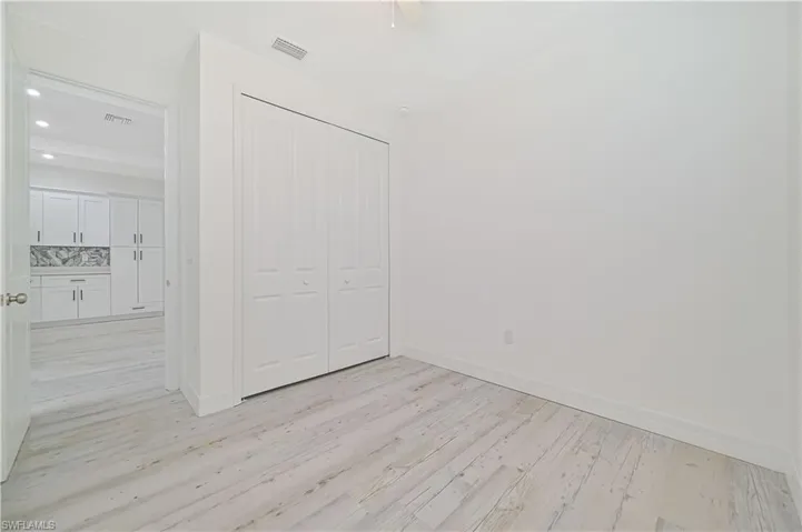 Unfurnished bedroom with light hardwood / wood-style flooring, a closet, and ceiling fan