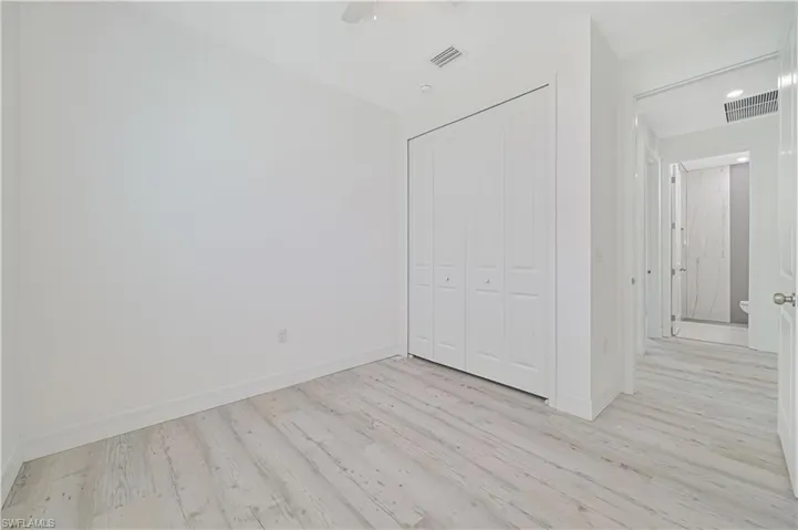 Unfurnished bedroom featuring ceiling fan, light wood-type flooring, and a closet