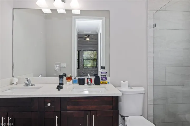Full bath with double vanity, toilet, and a sink