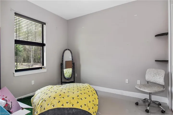Bedroom featuring baseboards and multiple windows