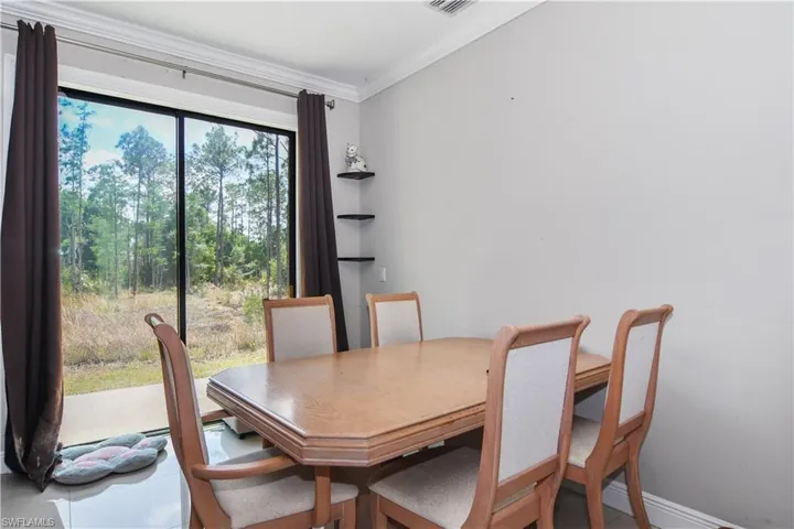 Dining room with baseboards, crown molding, and visible vents