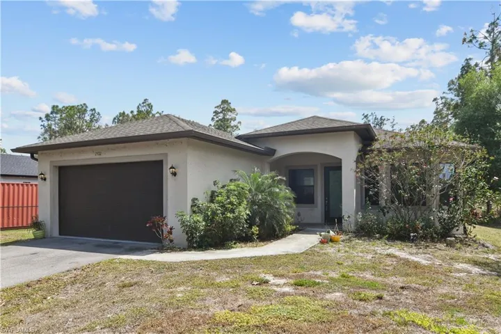 View of front facade with an attached garage, aphalt driveway, and stucco siding