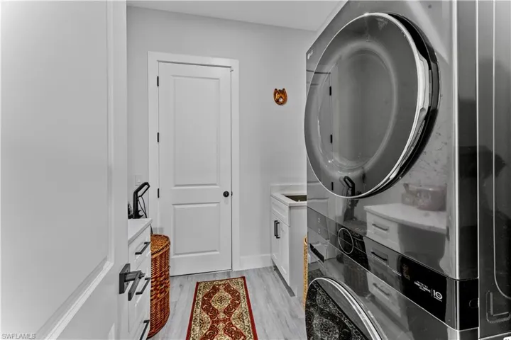Washroom with cabinets and light hardwood / wood-style floors