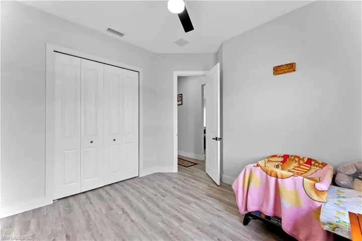 Bedroom with light hardwood / wood-style floors, a closet, and ceiling fan