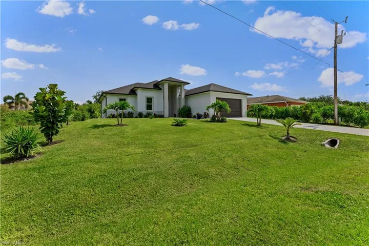 View of front of home with a garage and a front yard
