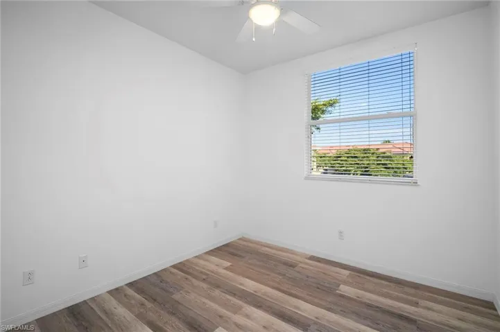 Empty room with wood finished floors and a ceiling fan